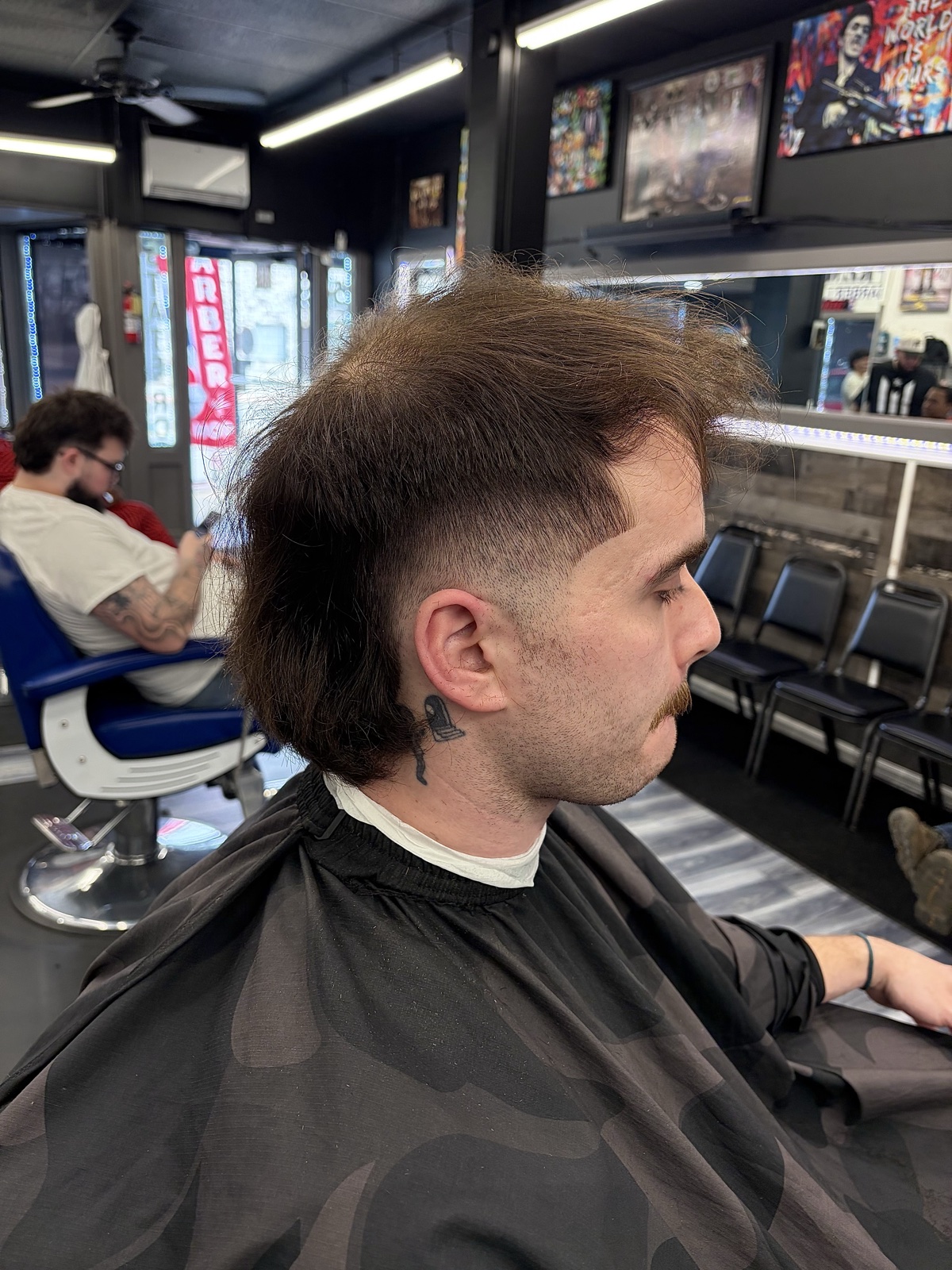 Eligio Roman — long-top mullet with skin fade and mustache