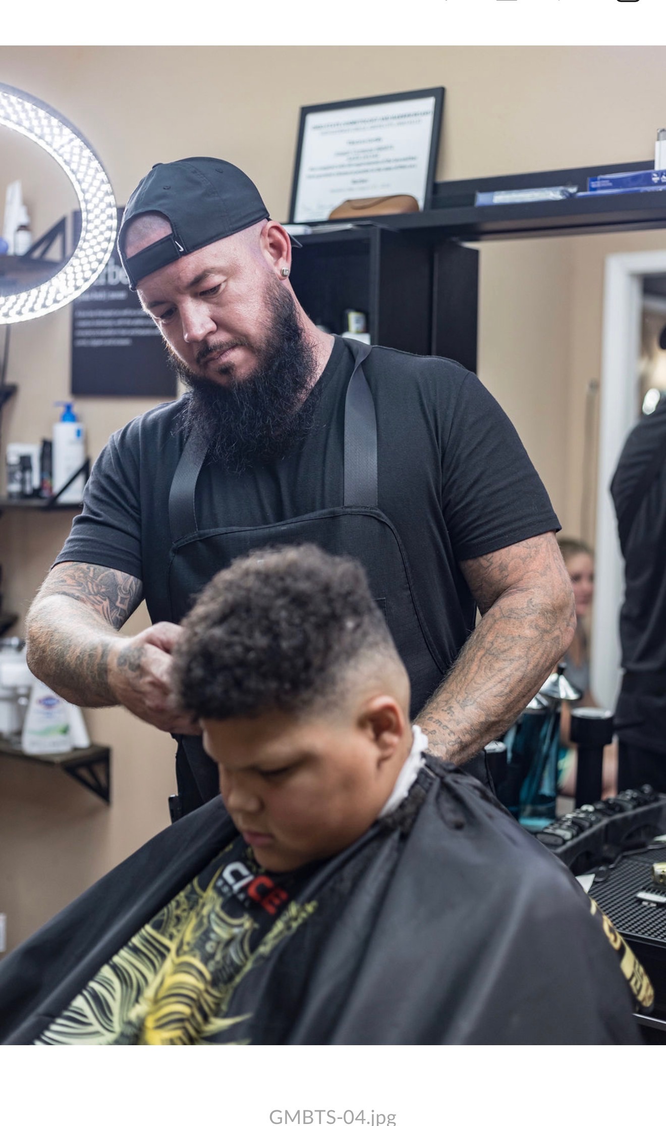 Joe cutting a young client's hair at the studio